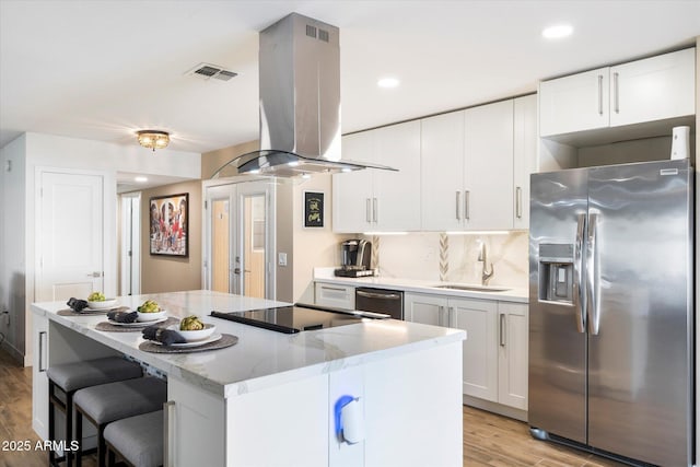 kitchen featuring white cabinetry, island exhaust hood, stainless steel appliances, and sink