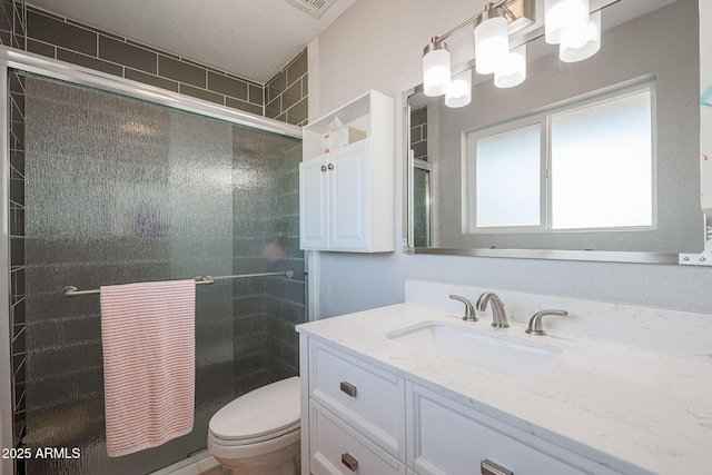 bathroom featuring vanity, toilet, and walk in shower