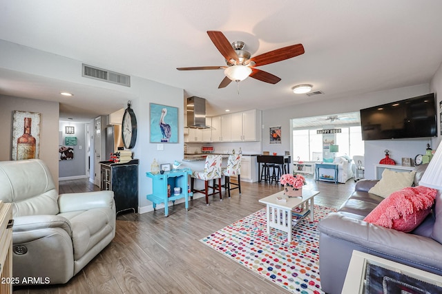 living room with light hardwood / wood-style flooring and ceiling fan