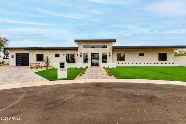 contemporary home featuring a garage and a front lawn