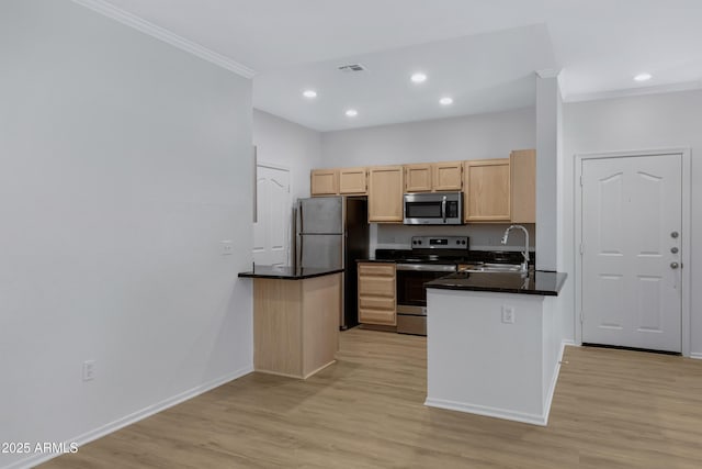 kitchen with a peninsula, stainless steel appliances, light brown cabinetry, light wood-type flooring, and a sink