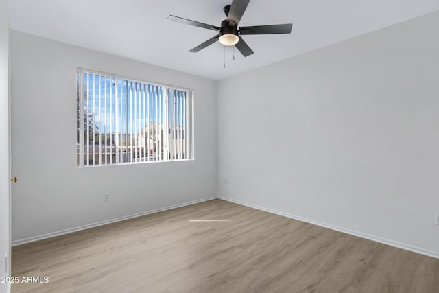 spare room with a ceiling fan, baseboards, and wood finished floors