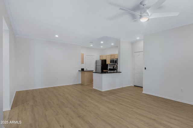 kitchen featuring dark countertops, light wood-type flooring, appliances with stainless steel finishes, and open floor plan