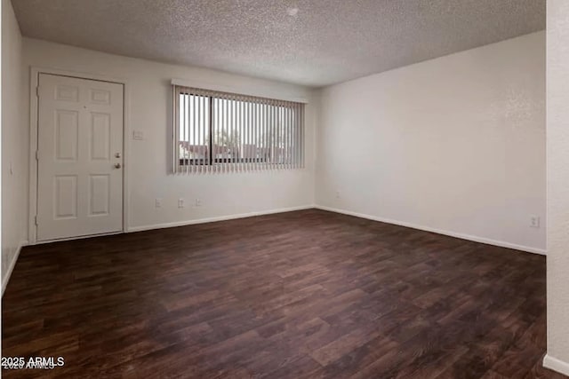 unfurnished room featuring a textured ceiling, baseboards, and dark wood-style flooring