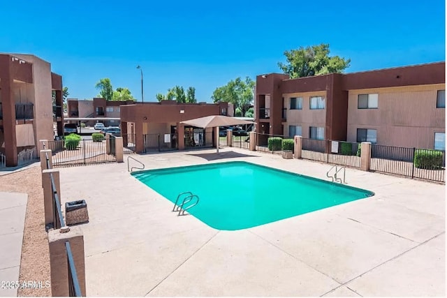 community pool with fence and a patio area