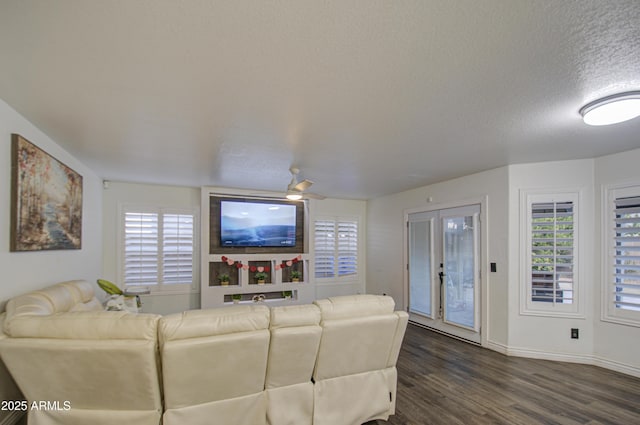 living room featuring dark wood-type flooring, a textured ceiling, and plenty of natural light