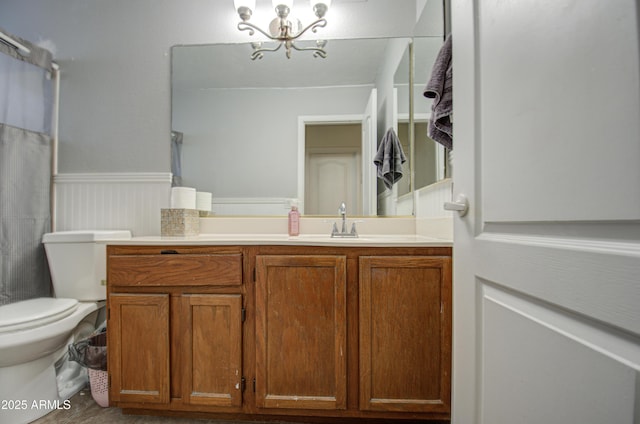 bathroom featuring toilet, vanity, and a notable chandelier