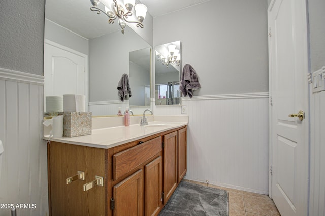 bathroom with tile patterned floors, vanity, and an inviting chandelier