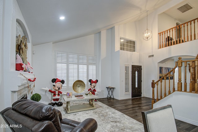 entrance foyer featuring dark hardwood / wood-style flooring, high vaulted ceiling, and a notable chandelier