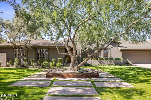 view of front of home featuring a front yard and a garage