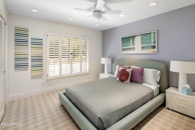 bedroom featuring light colored carpet, a closet, and ceiling fan