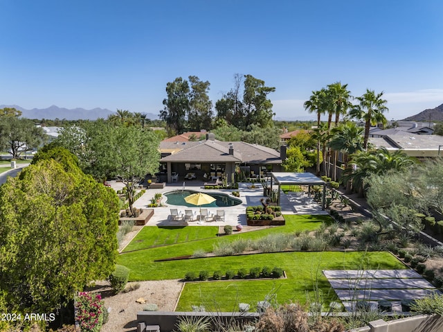 exterior space with a yard, a mountain view, and a patio