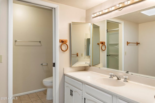 bathroom featuring vanity, tile patterned flooring, toilet, and baseboards