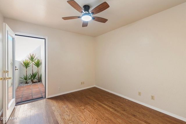 spare room featuring ceiling fan, baseboards, and wood finished floors