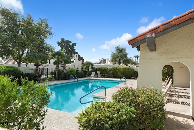 community pool featuring a patio area and fence