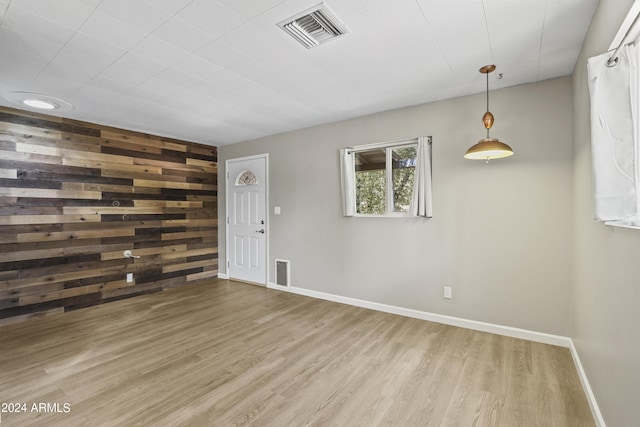 empty room featuring hardwood / wood-style flooring and wood walls