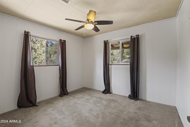 carpeted spare room featuring ceiling fan