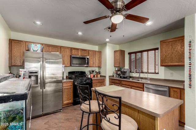 40264 W Lococo St, Maricopa, AZ 85138 - kitchen with ceiling fan, a sink, brown cabinetry, stainless steel appliances, and a kitchen island