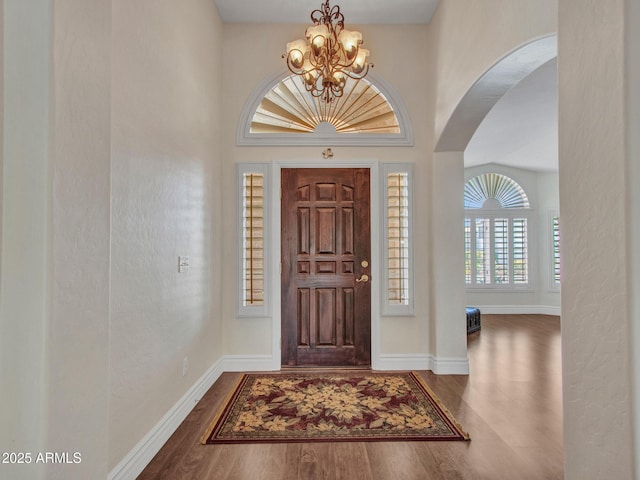19506 N 73rd Ave, Glendale, AZ 85308 - entrance foyer featuring a chandelier, arched walkways, wood finished floors, and baseboards