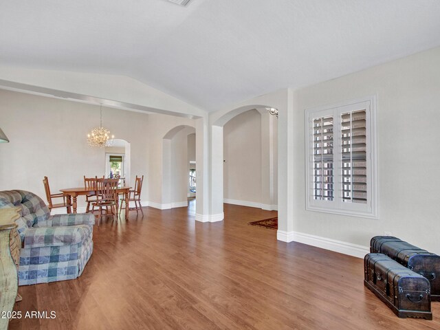 19506 N 73rd Ave, Glendale, AZ 85308 - living area featuring arched walkways, lofted ceiling, wood finished floors, a chandelier, and baseboards