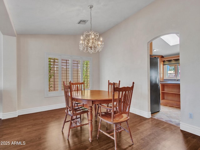 19506 N 73rd Ave, Glendale, AZ 85308 - dining space with arched walkways, wood finished floors, healthy amount of natural light, baseboards, and vaulted ceiling