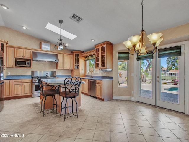19506 N 73rd Ave, Glendale, AZ 85308 - kitchen with wall chimney exhaust hood, stainless steel appliances, vaulted ceiling, healthy amount of natural light, and a skylight