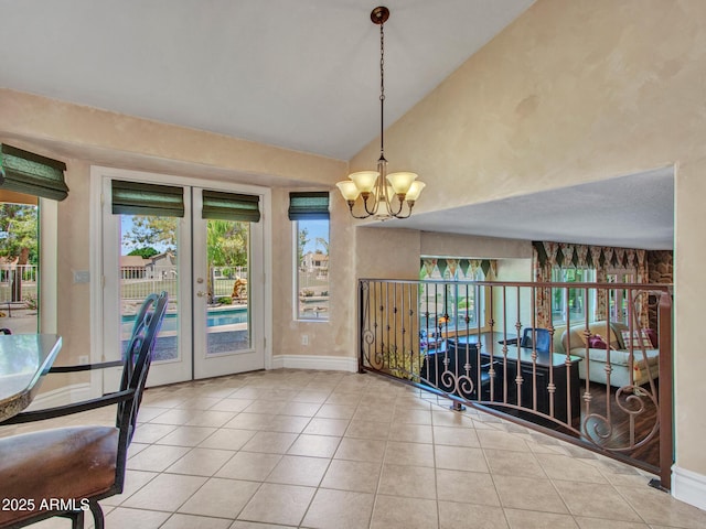 19506 N 73rd Ave, Glendale, AZ 85308 - unfurnished dining area with a chandelier, lofted ceiling, tile patterned flooring, baseboards, and french doors