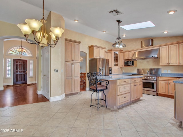 19506 N 73rd Ave, Glendale, AZ 85308 - kitchen featuring appliances with stainless steel finishes, arched walkways, a center island, a chandelier, and ventilation hood