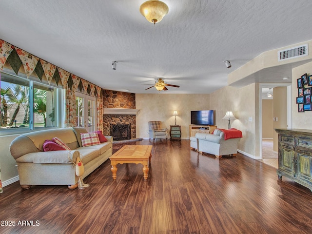 19506 N 73rd Ave, Glendale, AZ 85308 - living room featuring a textured ceiling, a stone fireplace, wood finished floors, a ceiling fan, and baseboards