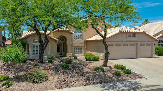 19506 N 73rd Ave, Glendale, AZ 85308 - mediterranean / spanish-style home featuring an attached garage, a tiled roof, concrete driveway, and stucco siding