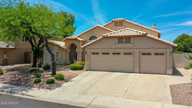 19506 N 73rd Ave, Glendale, AZ 85308 - mediterranean / spanish-style home featuring a tiled roof, an attached garage, driveway, stucco siding, and a chimney