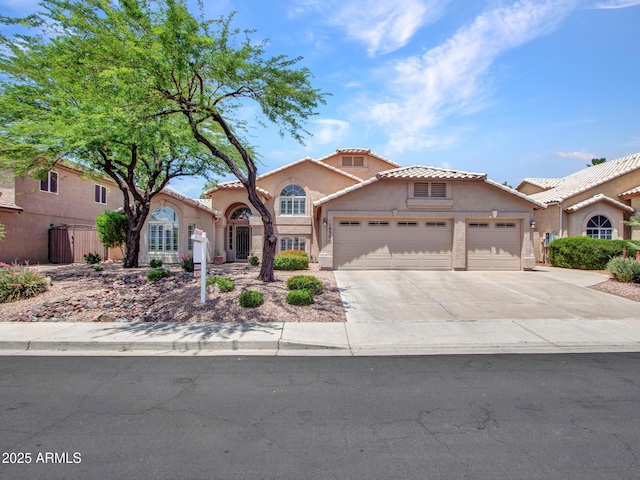 19506 N 73rd Ave, Glendale, AZ 85308 - mediterranean / spanish house featuring an attached garage, stucco siding, a tile roof, and concrete driveway