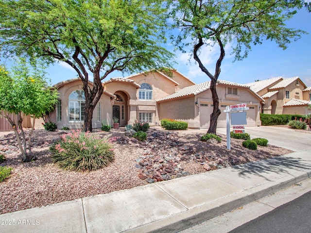 19506 N 73rd Ave, Glendale, AZ 85308 - mediterranean / spanish-style home featuring stucco siding, a garage, driveway, and a tiled roof