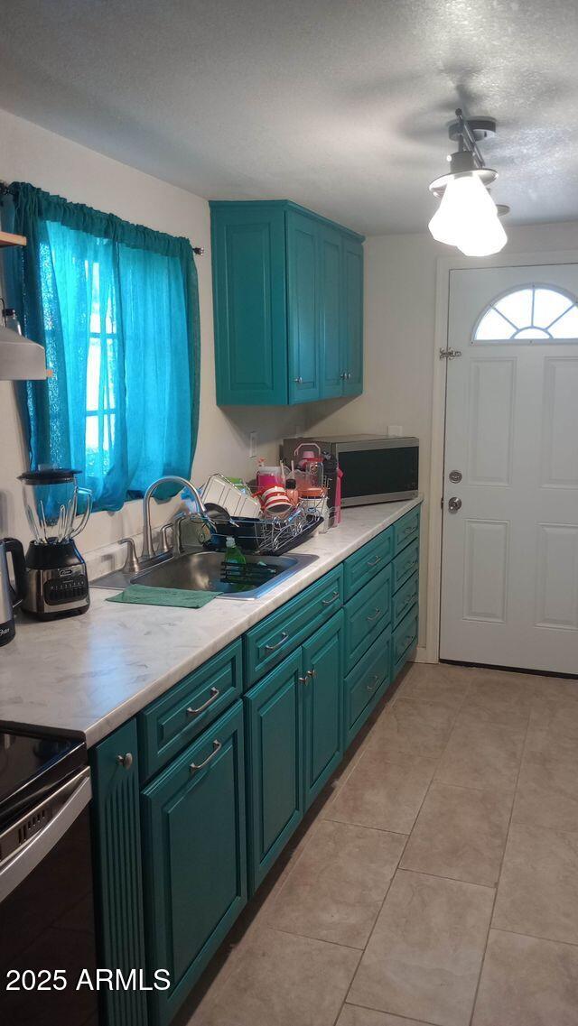 735 E 3rd St, Douglas, AZ 85608 - kitchen featuring light countertops, electric stove, light tile patterned floors, open shelves, and a textured ceiling