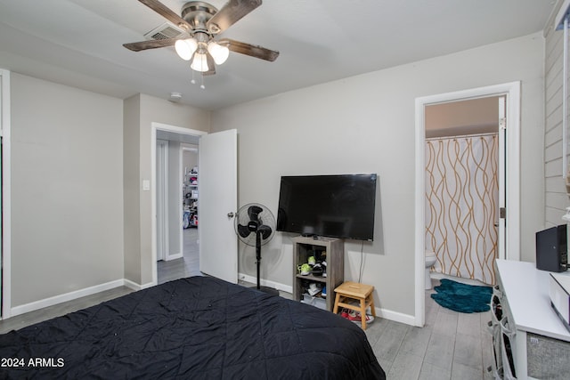bedroom with connected bathroom, a ceiling fan, wood finished floors, baseboards, and visible vents