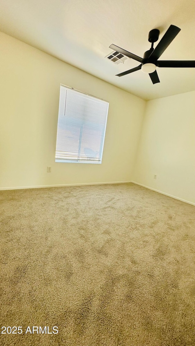 spare room featuring baseboards, visible vents, ceiling fan, and carpet flooring