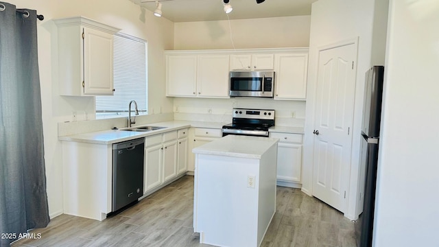 kitchen featuring light wood-type flooring, white cabinetry, appliances with stainless steel finishes, and a sink