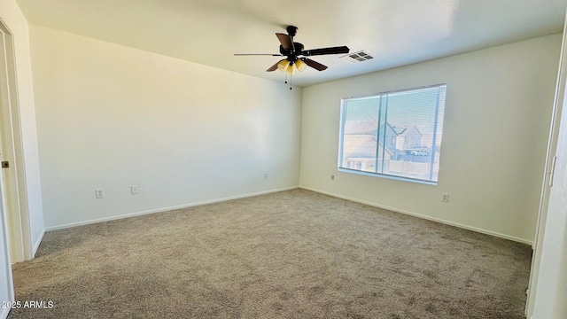 carpeted empty room with visible vents, ceiling fan, and baseboards