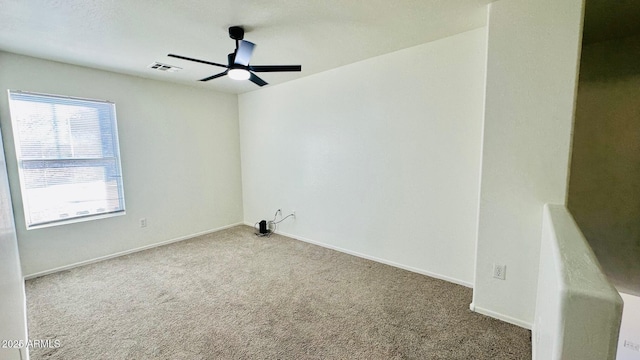 unfurnished room featuring baseboards, carpet, visible vents, and a ceiling fan