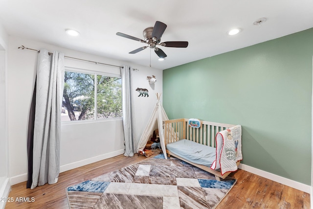 3508 E Gelding Dr, Phoenix, AZ 85032 - bedroom featuring wood finished floors, baseboards, recessed lighting, a ceiling fan, and a nursery area