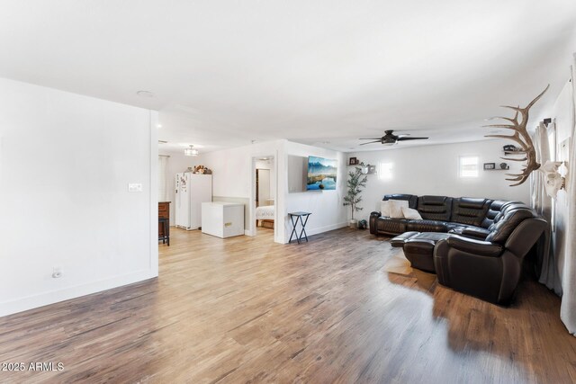 3508 E Gelding Dr, Phoenix, AZ 85032 - living room featuring light wood-style flooring, a ceiling fan, and baseboards