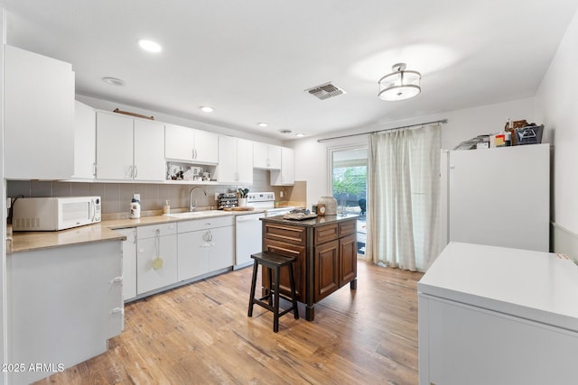 3508 E Gelding Dr, Phoenix, AZ 85032 - kitchen featuring white appliances, light wood-type flooring, backsplash, open shelves, and a sink