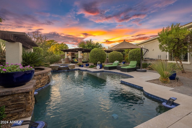 pool at dusk with an in ground hot tub, a gazebo, and a patio area