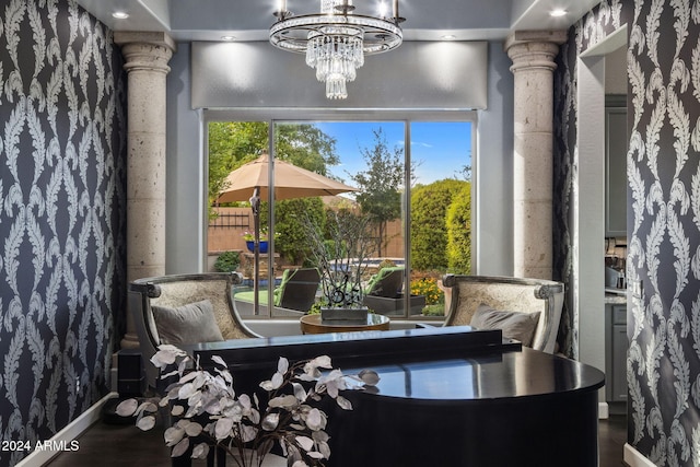 interior space featuring decorative columns, a chandelier, wood-type flooring, and a healthy amount of sunlight