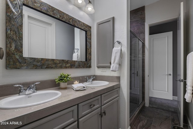 bathroom featuring a shower with door and vanity