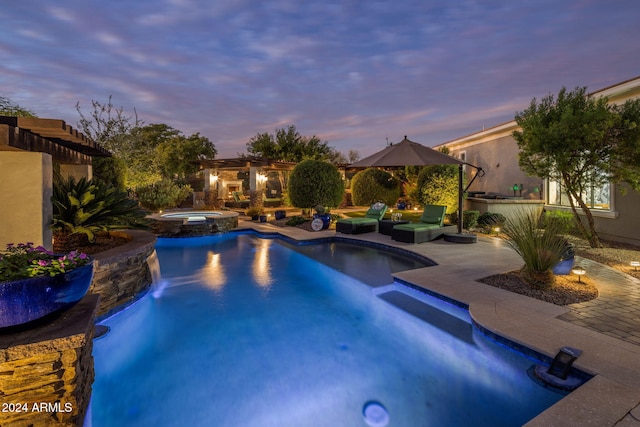 pool at dusk featuring a patio and an in ground hot tub