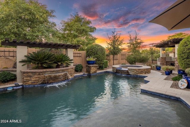 pool at dusk with an in ground hot tub and pool water feature