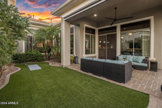 yard at dusk with an outdoor living space, a patio area, and ceiling fan