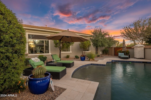 pool at dusk featuring a patio