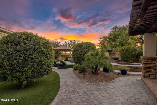 yard at dusk with a playground, a patio, an in ground hot tub, and a gazebo